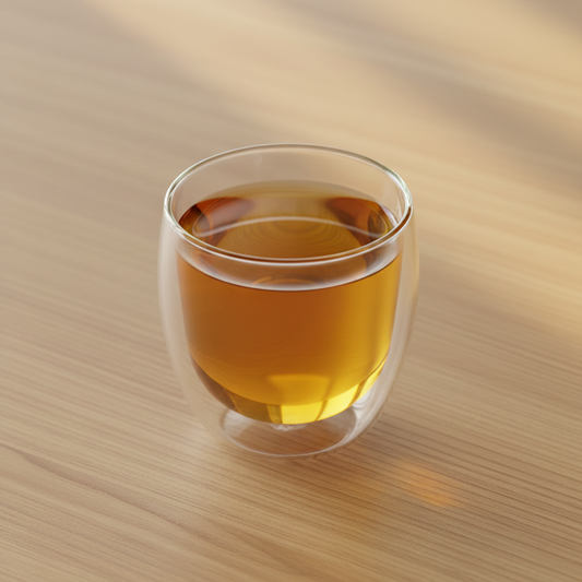 Infusión de hipérico en taza de doble vidrio térmico sobre mesa minimal