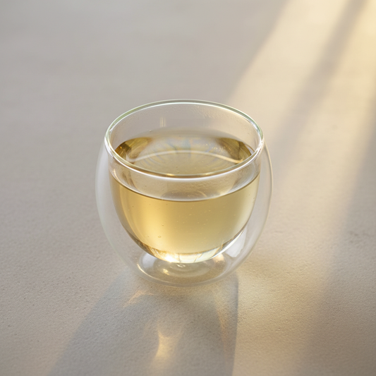 Infusión de cola de caballo en taza de doble vidrio térmico sobre mesa minimal