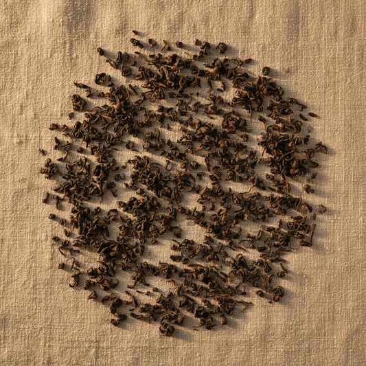 Hojas finas de té negro turco çay sobre lienzo de lino con luz dorada natural, composición minimalista